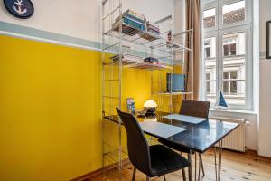 a dining room with yellow walls and a table and chairs at Ferienwohnung Rügen in Stralsund +11 photos