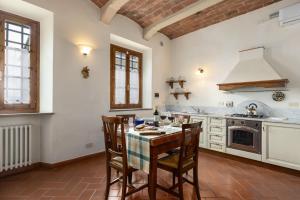 a kitchen with a table and chairs and a stove at Podere San Bartolo- Casa colonica 3 in Barberino di Val dʼElsa