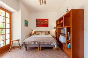 a bedroom with a bed and a book shelf at Logement de charme les Araucarias in La Garde