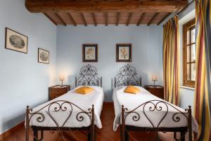 two beds in a room with white walls at Podere San Bartolo- Casa colonica 3 in Barberino di Val dʼElsa +30 photos