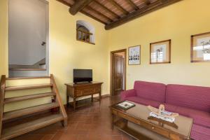 a living room with a purple couch and a table at Podere San Bartolo- Casa colonica 3 in Barberino di Val dʼElsa