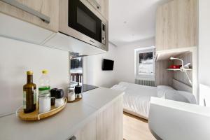 a kitchen with a counter with bottles and a bed at Dolomiti e Misurina My dreams in Misurina