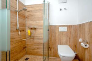 a bathroom with a toilet and a glass shower at Ferienwohnung Hafen in Neuendorf am See +6 photos