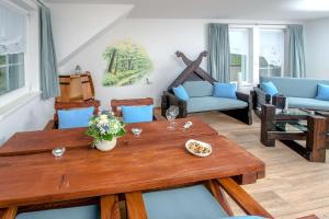 a living room with a wooden table and blue chairs at Ferienwohnung Hafen in Neuendorf am See