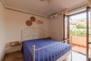 a bedroom with a bed and a balcony at Villa Marisol Agrustos in Budoni