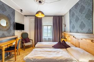 a hotel room with two beds and a desk at Residence Grünbacher in Issengo +122 photos