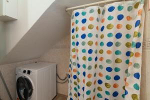 a laundry room with a shower curtain with a washing machine at Villa Marisol Agrustos in Budoni