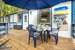 a patio with a table and chairs and an umbrella at Bungalow Kay, Bgl 4 in Dranske