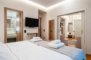 a bedroom with two beds and a flat screen tv at The Apex Boutique Apartment B1 in Athens