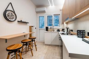 a kitchen with wooden stools and a counter top at The Apex Boutique Apartment B1 in Athens