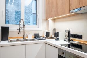 a white kitchen with a sink and a window at The Apex Boutique Apartment B1 in Athens +12 photos