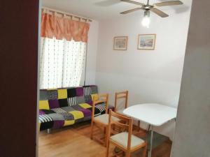 a living room with a table and a couch at Roses in Roses +1 photo