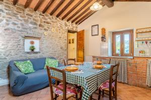 a living room with a table and a blue couch at Il Colletto Romantic Stonehouse in Pescia