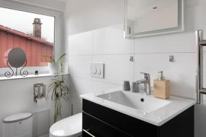 a white bathroom with a sink and a toilet at Ferienhaus Engelsberghof in Endingen +44 photos