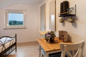 a room with a table and a bed and a window at Ferienhaus Engelsberghof in Endingen