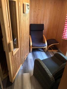 a living room with a chair and a chair at Urige idyllische Hütte mit Sauna in Grainet +3 photos