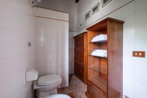 a bathroom with a toilet and a wooden cabinet at Casaletto della musica in Viterbo +16 photos