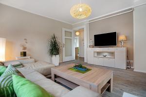 ein Wohnzimmer mit Sofa und Fernseher in der Unterkunft Ferienwohnung Bleichen in Stralsund