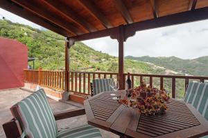 a table and chairs on a deck with a view at Complejo Rural Pajar de Bento in Agulo