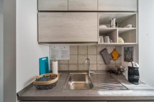 a kitchen counter with a sink and cabinets at Casa Royale Appartamento Terra in Lierna +18 photos