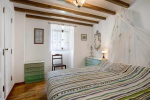 a bedroom with a large bed and a chair at Casa do Largo in Mendiga