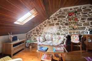 a living room with a couch and a stone wall at Casa do Largo in Mendiga