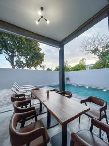 a patio with a table and chairs and a pool at X Hostel Jogja in Timuran