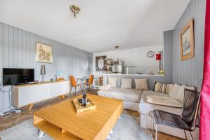 a living room with a couch and a table at Échappée Bel in Arveyres