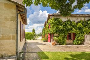 an alley between two buildings with a red door at Échappée Bel in Arveyres