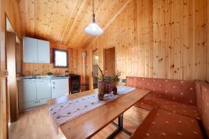 a wooden room with a table and a kitchen at Casa Ciclamino in Barzio
