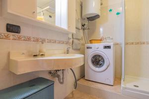 a bathroom with a sink and a washing machine at Casa Verdeblu in Porto Azzurro