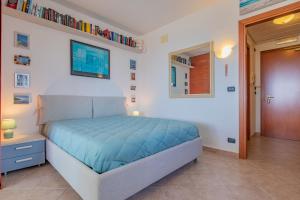 a bedroom with a bed with a blue comforter at Casa Verdeblu in Porto Azzurro