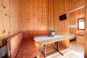 a room with a bench and a table with flowers on it at Casa Ciclamino in Barzio