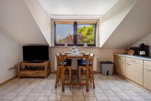 a kitchen with a table with chairs and a window at Ferienwohnung Thomée in Looft