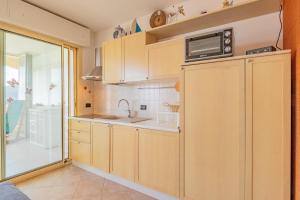 a kitchen with a sink and a microwave at Casa Verdeblu in Porto Azzurro +25 photos