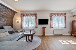 a living room with a couch and a flat screen tv at Carpe Diem - Ferienwohnung in Görlitz