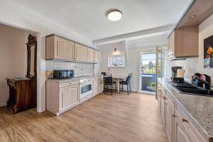 a kitchen with white cabinets and a table with chairs at Carpe Diem - Ferienwohnung in Görlitz