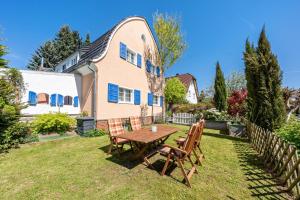 a backyard with a wooden table and chairs at Carpe Diem - Ferienwohnung in Görlitz