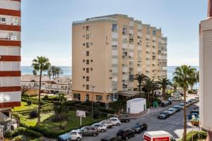 a tall building with cars parked in a parking lot at Estudios 88 in Torrox
