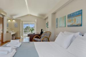 a bedroom with a large white bed and a desk at Artemida Beach House in Artemida
