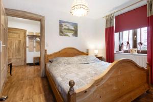 a bedroom with a wooden bed and a chandelier at Buchhaus Vier - Erdgeschoss in Kirchenlamitz