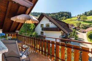 a balcony with a table and an umbrella at Haus Berger in Seebach