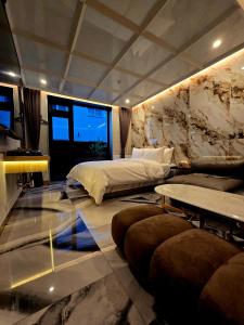 a bedroom with a bed and a couch and tables at 델루나호텔 부평점 in Incheon +40 photos