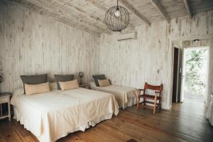 a bedroom with two beds and a chair at Posada Las Aguas in Gualeguaychú +85 photos