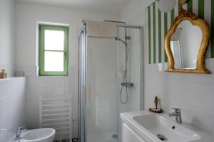 a white bathroom with a shower and a sink at Alsópetényi Vendégházak in Alsópetény +57 photos