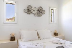 a white bedroom with a bed and two windows at Ow Andros Suite 3,Private Whirlpool in Andros