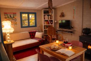 a living room with a couch and a table with wine glasses at Chalet Le Puy Papillon in Servières-le-Château