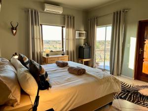 a bedroom with a bed with two pillows on it at Boscia African Farm in Omomas