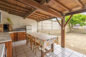 a kitchen with a table and chairs in a kitchen at Maison de vacances centre ville in La Tremblade +16 photos