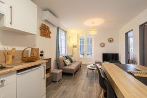 a kitchen and living room with a couch and a table at Maison de vacances centre ville in La Tremblade